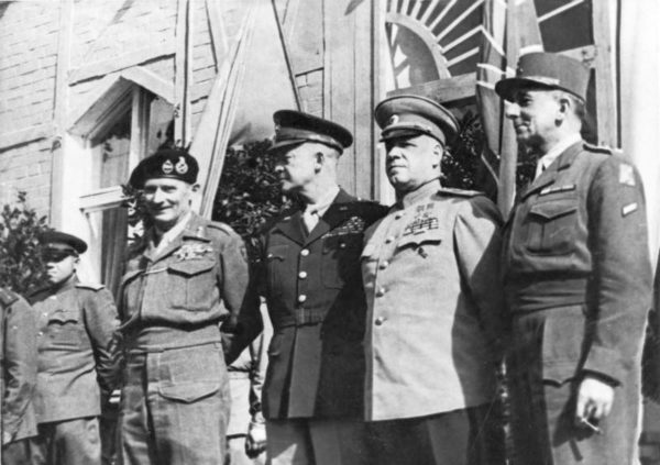 The four WWII allied military leaders: Field Marshal Bernard Montgomery (British—far left), General Dwight D. Eisenhower (American—middle left), Marshal Georgi K. Shukow (Soviet Union—middle right), and General Jean de Lattre de Tassigny (France—far right) in Berlin. Photo by anonymous (c. June 1945). Bundesarchiv, Bild 183-14059-0018/CC-BY-SA 3.0. Wikimedia Commons.