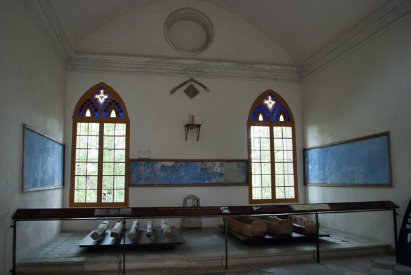 Interior of the chapel at Mont-Valérien. The five wooden stakes that the victims were tied to lie to the left while several body boxes used to transport the bodies lie to the right—in front of the two windows. Photo by Sandy Ross.