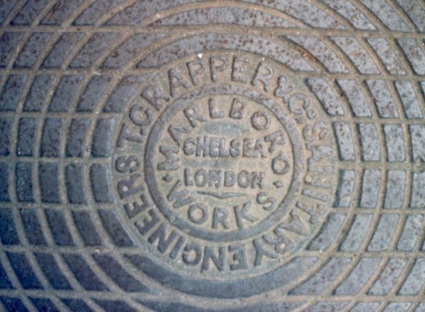 A genuine Crapper manhole cover. Photo by Patrick Mackie (1988). © Patrick Mackie and licensed under Creative Commons Attribution-ShareAlike 2.0. Wikimedia Commons.