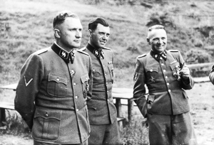 Three SS officers socialize on the grounds of the SS retreat outside of Auschwitz. From left to right they are: Richard Baer (Commandant of Auschwitz), Dr. Josef Mengele, and Rudolf Hoess (former commandant of Auschwitz). Photo by Karl-Friedrich Höcker (c. 1944). PD-Release by Polish Government. Wikimedia Commons. 