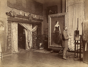 John Singer Sargent in his studio located at 41, boulevard Berthier. The 1884 Salon is over and he has retrieved his painting. Notice the strap on her right shoulder has been painted in by the artist. Photo by A. Giraudon (c. 1884). National Portrait Gallery. PD-70+. Wikimedia Commons. 