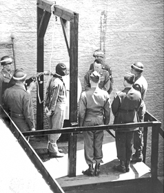 Photo of Reichhart adjusting rope prior to hanging Martin Weiss, former commandant of Dachau concentration camp. Photo likely by U.S. Army (May 1946). 