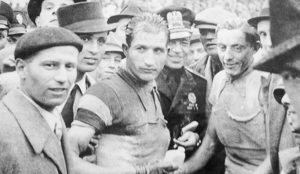 The two top Italian cyclists before and after World War II: Gino Bartali (center left) and Fausto Coppi (center right). Photo by anonymous (c. 1940−1943). Private Collection. PD-Expired Copyright. Wikimedia Commons. 