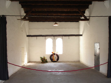 Interior of the execution chamber at Plötzensee Prison. Notice the steel beam and hooks in the background. In the foreground is the curtain separating the hanging area and where the guillotine was set-up. Photo by MisterBee1966 (February 2007). PD-CCA-Share Alike 3.0 Unported. Wikimedia Commons. 