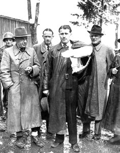 Nazi rocket scientists in U.S. Army custody. Walter Dornberger, second from left. Wernher von Braun in a left arm cast, center. Photo by T5C. Louis Weintraub (3 May 1945). PD-U.S. Government. Wikimedia Commons. 