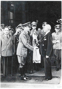 Adolf Hitler (front left) congratulating Gustav Krupp (front right) on receiving the gold medal of the NSDAP (Nazi Party). Photo by anonymous (13 August 1940). Nationaal Archief. PD-Expired Copyright. Wikimedia Commons. 