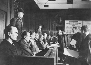 Defendants in the Krupp Trial sit in the dock. Nearest to the camera is Alfried Krupp. Photo by anonymous (December 1947). German Federal Archives. PD-Bundesarchiv, Bild 183-R93432/CC-BY-SA 3.0. Wikimedia Commons. 