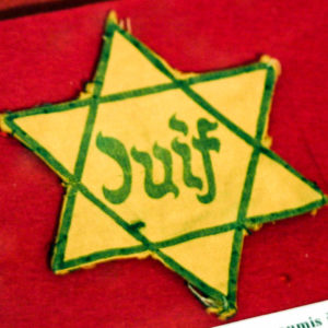 Yellow star saying "juif” made mandatory for French Jews during the occupation of France. Photo by Rama (date unknown). Kitkatcrazy at en.wikipedia (http://en.wikipedia.org). PD-CCA-Share Alike 3.0. Wikimedia Commons.