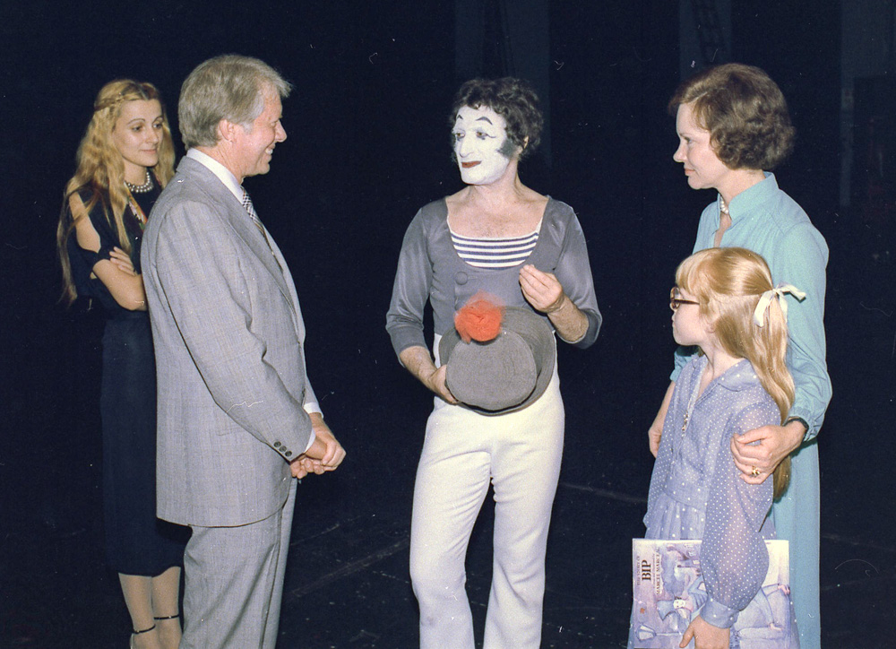 Marcel Marceau as Bip the Clown (center) with President Jimmy Carter and his family. Photo by anonymous (June 1977). U.S. National Archives and Records Administration. PD-U.S. Government. Wikimedia Commons.