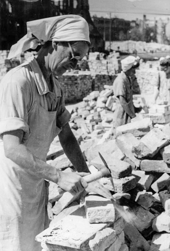 Dresden “Trümmerfrau” (Rubble Woman or Brick Lady) clearing Dresden of the bricks after the end of the war. Dresden was destroyed by Allied bombing and a devastating firestorm. Photo by anonymous (c. 1948). Bundesarchiv, Bild 183-H26824/CC-BY-SA 3.0. Wikimedia Commons.