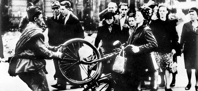 Soviet soldier trying to take a bicycle away from a German woman. Photo by anonymous (c. 1945). 