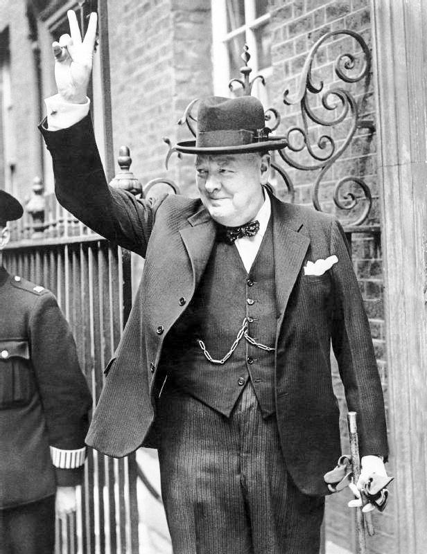 Winston Churchill in Downing Street giving his famous “V” sign. Photo by British Government (5 June 1943). Imperial War Museum. PD-British Government Public Domain. Wikimedia Commons.