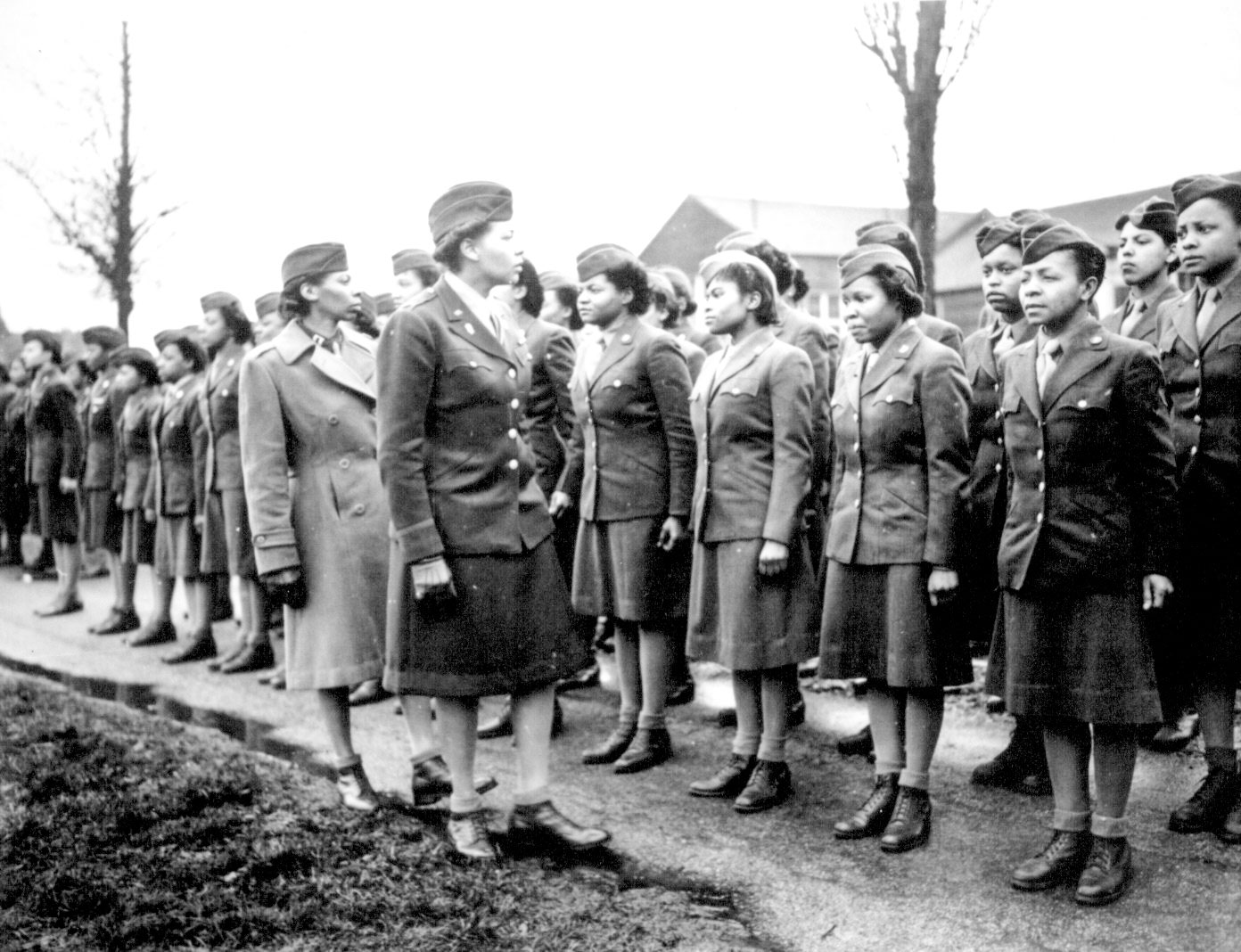 Somewhere in England, Major Charity E. Adams and Capt. Abbie N. Campbell inspect the first contingent of African-America members of the Women’s Army Corps assigned to overseas service. Photo by anonymous (15 February 1945). National Archives and Records Administration. PD-U.S. Government. Wikimedia Commons.