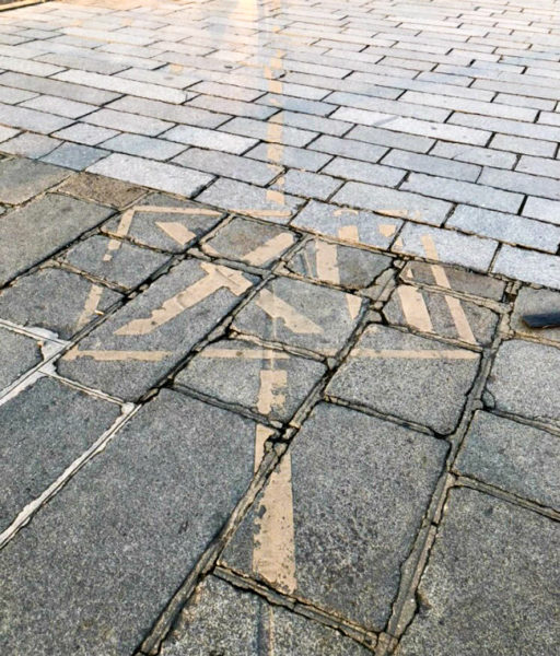 Roman numeral on the pavement at the Place de la Concorde. Photo by Claudine Hemingway (date unknown). Bonjour Paris.