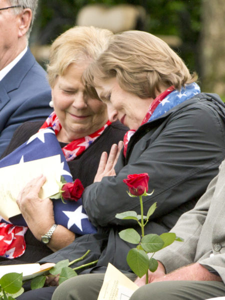 Family members of the Pieper twins. Linda Pieper Suitor (left) and Susan Lawrence, hug during the reburial service for their uncle. Photo by anonymous (19 June 2018).