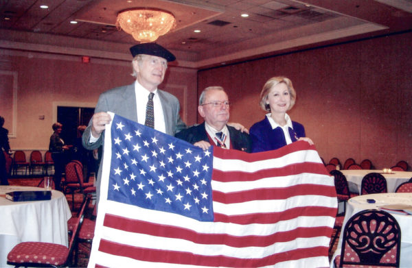 American flag presented to Jean-Jacques by Rep. Gingrey at the reception held in honor of Jean-Jacques: Ken Kirk (left), Jean-Jacques (center), and Claire Kirk (right). Photo by anonymous (c. 2007). Courtesy of Ken Kirk.