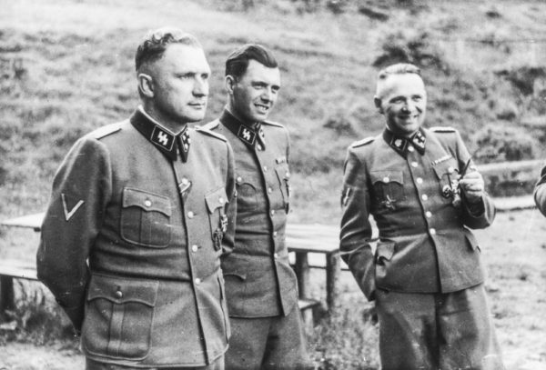 Three SS officers socializing near Auschwitz: Richard Baer (left; Commandant of Auschwitz), Dr. Josef Mengele (center), and Rudolf Höss (right; former and longest serving commandant of Auschwitz). Photo by anonymous (c. 1944). PD-Poland. Wikimedia Commons.