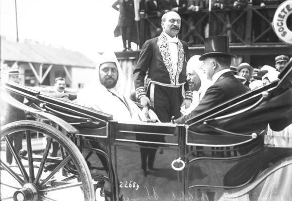 The préfet of Bouches-du-Rhône, Abraham Schrameck (standing) and the Sultan of Morocco, Mulai Abdelhafid (left) and Benghabrit (second from right). Photo by anonymous (15 June 1912). Agence Rol and Bibliothèque nationale de France. PD-Reproduction of public domain image. Wikimedia Commons.