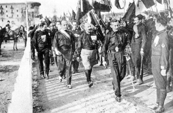 Benito Mussolini (second from left) marching on Rome with 40,000 fascist followers. Photo by anonymous (24 October 1922). Illustrazione Italiana, 1922, no. 45. PD-Expired Copyright. Wikimedia Commons.