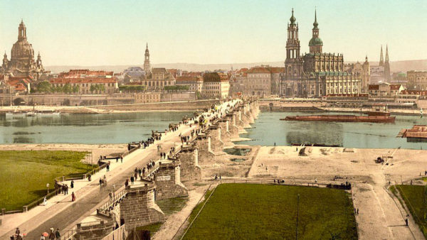 Dresden in 1900. The Augustus Bridge, crossing the Elbe River, connects the North Bank of the Innere Neustadt (foreground) to the historic City Center (South Bank-far side of river). The Frauenkirche is on the far left while the Catholic Hofkirche is center right. Photo by anonymous (c. 1900). Getty Images.