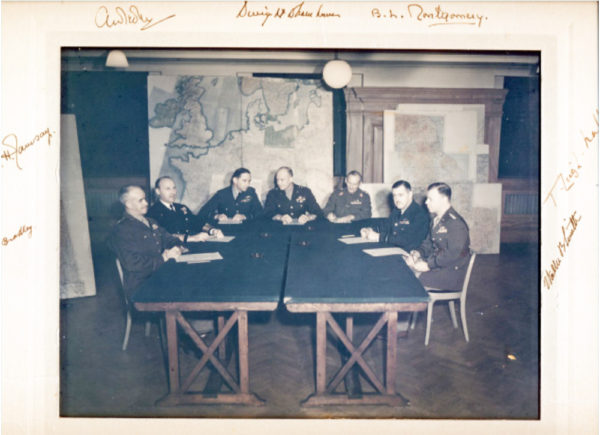 Invasion planning committee. Left to right: General Bradley, Admiral Ramsay, Air Chief Marshal Sir Arthur Tedder, General Eisenhower, General Sir Bernard Montgomery, Air Chief Marshal Sir Trafford Leigh-Mallory, and General Walter Bedell Smith. Photo by anonymous (c. 1944)). St. Paul’s School.