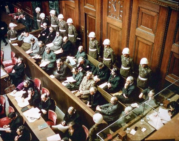 View of the defendants in the dock at the International Military Tribunal trial of war crimes in Nuremberg. Photo by anonymous (c. November 1945). PD-U.S. Government. Wikimedia Commons.