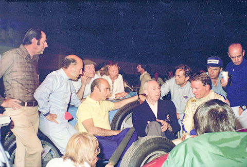 Réne Dreyfus (blue sport coat, center) speaking with F1 drivers at the 1976 Long Beach Vintage Grand Prix. Photo by anonymous (c. April 1976).
