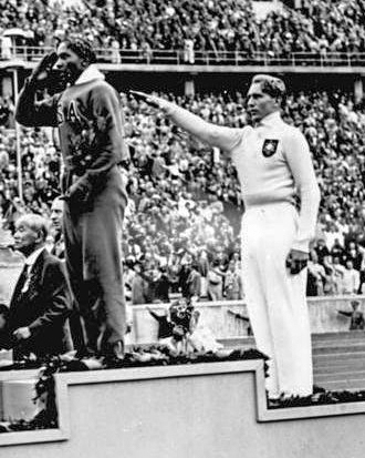 Luz Long, German athlete saluting Hitler (right), on the winners stand at the 1936 Berlin Olympics. Jesse Owens (left) on the podium after winning the gold medal. Photo by anonymous (c. August 1936). Bundesarchiv Bild 183-G00630, Sommerolympiade, Siegerehrung Weitsprung. PD-CCA-Share Alike 3.0 Germany. Wikimedia Commons.