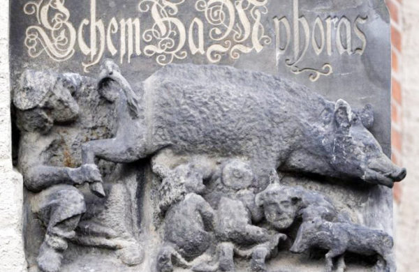 Carving from the Middle Ages showing a rabbi (left) and two other Jews with a pig. Photo by anonymous (date unknown). EPA.