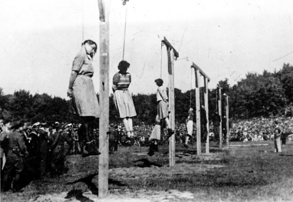 Execution of Stutthof concentration camp overseers at Biskupia Górka. From left to right: Jenny-Wanda Barkmann, Ewa Paradies, Elisabeth Becker, Wanda Klaff, and Gerda Steinhoff. Further in the background is the guard SS-Oberscharführer Johann Pauls and several Polish kapos. Photo by Polish authorities (4 July 1946). PD-Polish Public Domain.