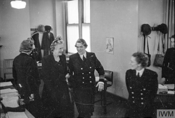 Mrs. Winston Churchill visits the WRNS headquarters and is introduced to each department head by Director V. Laughton Mathews (to the right of Mrs. Churchill). Photo by anonymous (September 1941). Admiralty Official Collection. PD-Expired copyright. Wikimedia Commons.