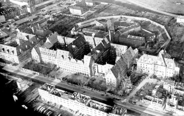 Aerial view of the Nuremberg Palace of Justice. The prison building with its four wings are behind the palace of justice. The wing to the right housed the Nazi defendants. Just to the right of the wing stands the prison gymnasium. Photo by anonymous (winter 1945/46). Nuremberg Municipal Archives. 