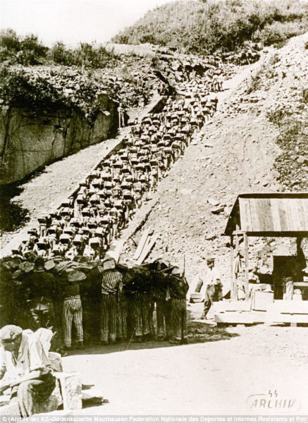 Nazi prisoners carrying heavy stones from a nearby quarry up the “stairs of death” at the Mauthausen concentration camp in Austria. SS guards would often push weary, starving inmates over the quarry wall to their deaths. Photo by anonymous (c. 1942). ©️ Archiv der KZ-Gedenkstaette Mauthausen; Fédération nationale des deportés et internes résistants et patriotes.