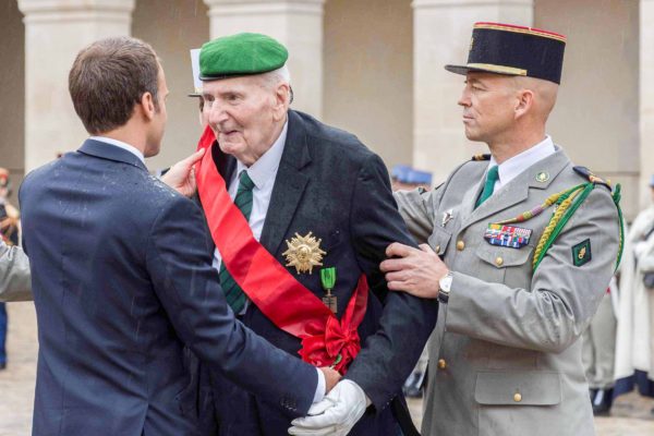 Hubert Germain, 98-years-old, greeting President Macron (left) of France. Photo by anonymous (c. 2019).