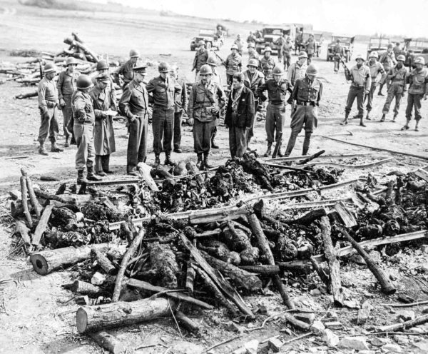 Gen. Eisenhower (third from left, front row), Gen. Bradley (fourth from left, front row), and Gen. Patton (far right, front row) inspect the corpses at Buchenwald Ohrdruf. Photo by anonymous (12 April 1945). United States Holocaust Memorial Museum. Courtesy of Harold Royall. PD-U.S. Government. Wikimedia Commons.