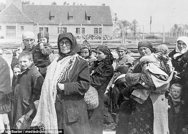 Jewish women and children walking toward the Auschwitz gas chambers. The building in the background is Crematorium III. Within an hour, everyone in this photo would be murdered. Photo by anonymous (date unknown). ©️ Ian Baxter/ mediadrumworld.com. 