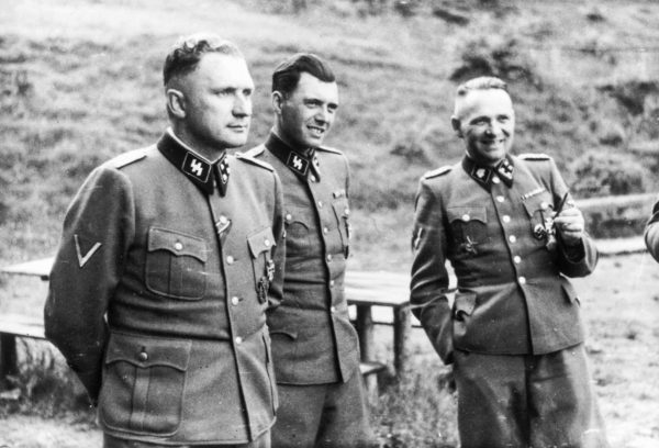 Left to right: Richard Baer (commandant of Auschwitz), Dr. Josef Mengele (Auschwitz doctor), and Rudolf Höss (former commandant of Auschwitz). Photo by anonymous (c. 1944). United States Holocaust Memorial Museum. Album Höcker. PD-Poland. Wikimedia Commons.