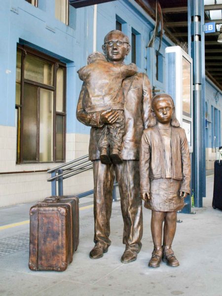 Memorial of Nicholas Winton, savior of 669 Jewish children, located in the Prague Main railway station. Photo by Ludêk Kovár. Sculpture by Flor Kent (September 2009). PD-GNU Free Documentation License. Wikimedia Commons. 