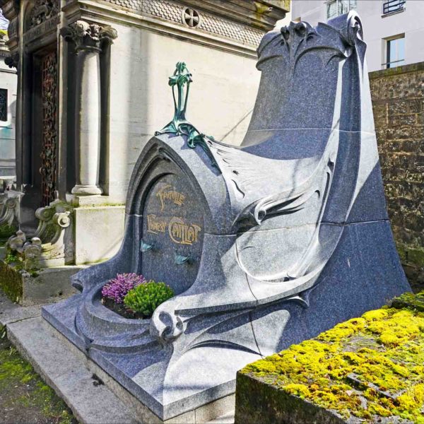 The tomb of Ernest Caillat and family, located in Père Lachaise cemetery, was designed by Hector Guimard. Photo by Jean -Pierre Dalbéra (March 2018). PD-CCA 2.0 Generic. Wikimedia Commons.