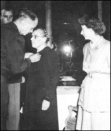 Marie-Louise Dissard (1880−1957) receiving the American Medal of Freedom. Andrée de Jongh is standing on the right. Photo by anonymous (c. 1947). www.spartacus-educational.com.