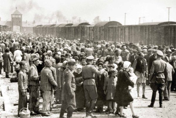 Sorting of deportees on the ramp at KZ Auschwitz II-Birkenau. The group on the left were destined for immediate death in the gas chambers while the group on the right would survive for the time being. Photo likely by E. Hoffmann or B. Walter (c. May 1944). PD-Expired copyright. Wikimedia Commons.