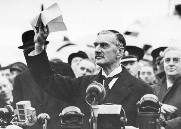 Neville Chamberlain, British prime minister, declaring “Peace in our time” upon his return to England. Photo by anonymous (30 September 1938). Poland National Archive. PD-CCA-Share Alike 4.0 International. Wikimedia Commons.