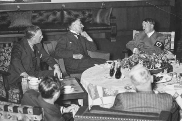 Munich conference. Clockwise from bottom right: Unknown, unknown, Joachim von Ribbentrop, Chamberlain, and Hitler. Photo by anonymous (c. September 1939). Bundesarchiv, Bild 146-1972-001-03/CC-BY-SA 3.0. PD-CCA-Share Alike 3.0 Germany. Wikimedia Commons.