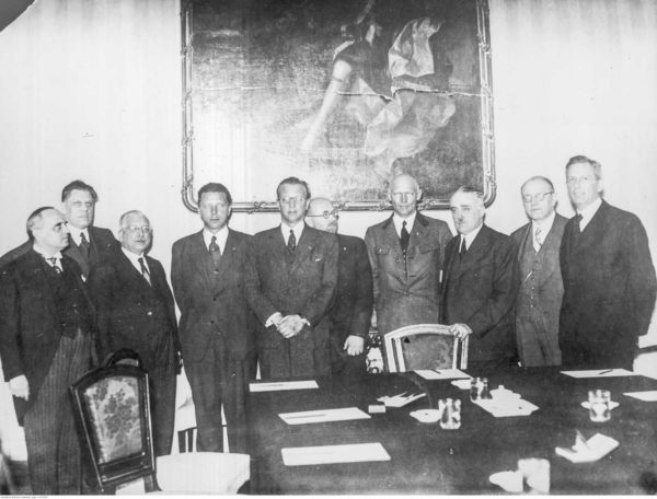 Arthur Seyss-Inquart’s first cabinet in the German-controlled Austria. Seyss-Inquart is fifth from the left. Photo by anonymous (11 March 1938). PD-Author release. Wikimedia Commons.