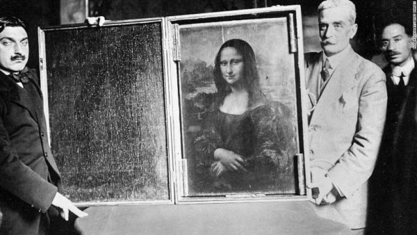 Two men carrying the Mona Lisa back to the Louvre. (Is that Hercule Poirot on the left?) Photo by anonymous (c. 1914). PD-Author’s life plus 70 years or fewer. Wikimedia Commons.