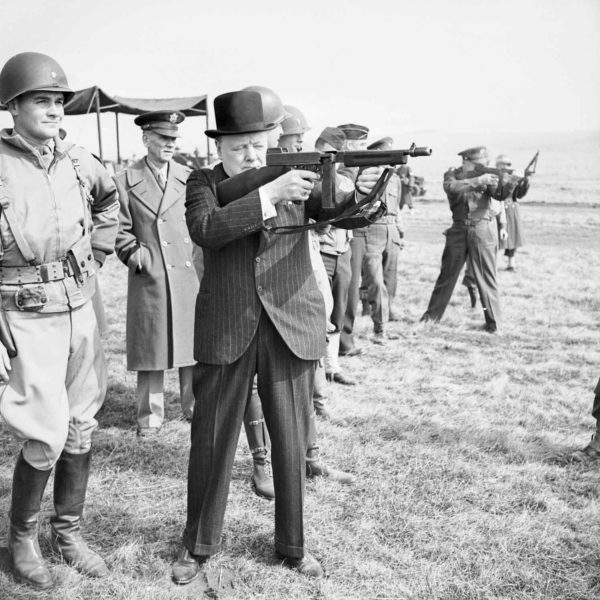 Winston Churchill fires a Thompson submachine gun. Photo by Capt. Horton (c. 1939-45). Imperial War Museum. PD-Expired copyright. Wikimedia Commons.