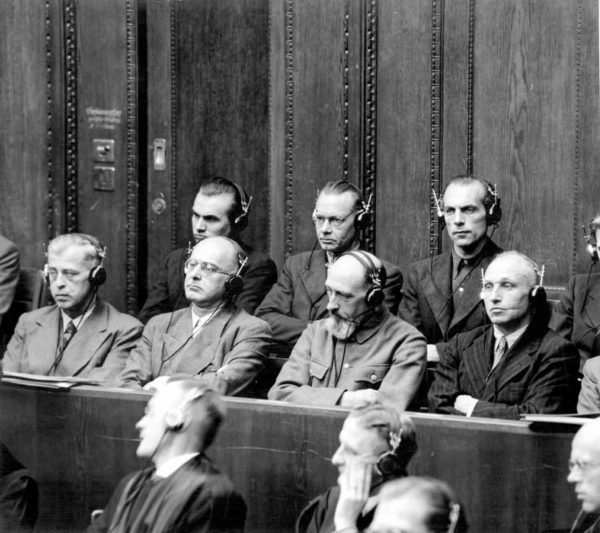 The defendants dock in the Einsatzgruppen trial. Front row, left to right: Erwin Schulz (20-years; released 1954), Franz Six (20-years; released 1952), Paul Blobel (death; executed), Walter Blume (death; released 1951). Back row, left to right: Adolf Ott (death; released 1958), Waldemar Klingelhoffer (death; released 1956), Lothar Fendler (10-years; released 1951). Photo by anonymous (c. 1947). Yad Vashem. PD-U.S. Government.