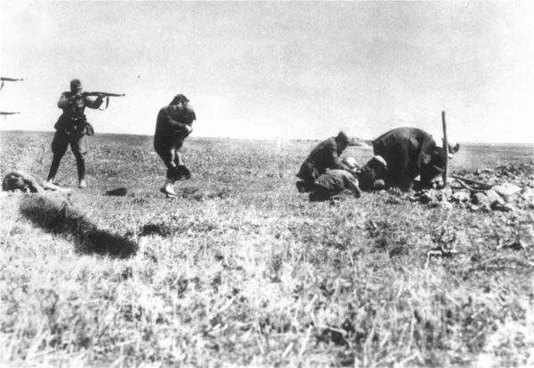 Executions of Jews by German army mobile killing units (Einsatzgruppen) near Ivangorod, Ukraine. The woman is holding a child. All victims in the photograph perished. Photo by anonymous (c. 1942). Historical Archives in Warsaw and private collection of Jerzy Tomaszewski. PD-Republic of Poland. Wikimedia Commons.