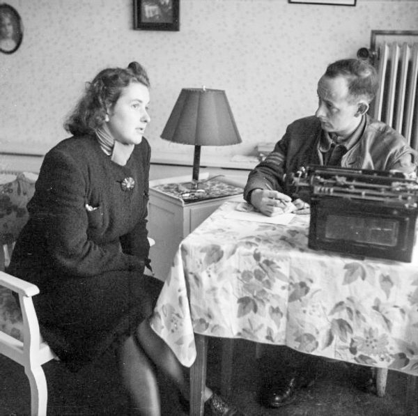 Clara Lackman, a typist at Gestapo headquarters in Lübeck, Schleswig-Holstein, Germany, is being interrogated by the British Field Security Police. Photo by Sgt. Laing (c. 1945). PD-U.K. Government. Wikimedia Commons.