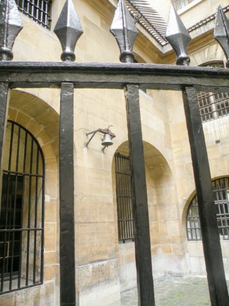 The women’s prison courtyard in the Conciergerie. Behind the fence (foreground) was the waiting area for the condemned before being led to the carts. The bell would be rung daily at 11:00 a.m. when it was time for the victims to leave for the guillotine. Photo by Chatsam (c. 2013). PD-CCA-Share Alike 3.0 Unported. Wikimedia Commons.